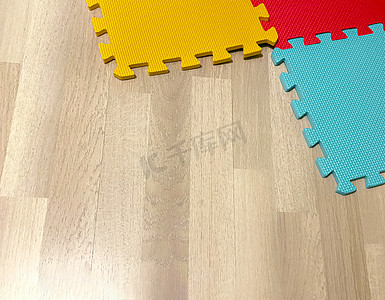 木地板上由相互交叉的彩色块组成的软橡胶垫