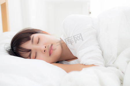 美丽的亚洲年轻女子躺在床上，头枕在 p 上睡觉