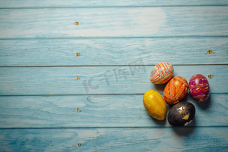 蓝色木质背景平躺上的复活节彩色彩绘鸡蛋