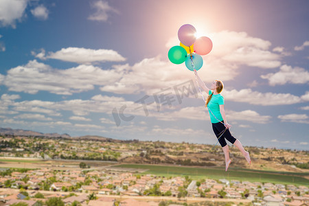 免费救援摄影照片_小女孩被她举在下方城镇上空的气球带走。