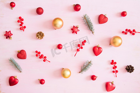 粉红色的木质圣诞背景与红色和金色圣诞装饰。