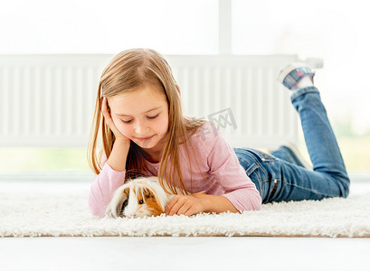 女孩抱着豚鼠在地板上