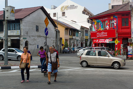 马来西亚槟城摄影照片_马来西亚槟城乔治城 — 2016年4月18日：当地人和汽车在街道上行走