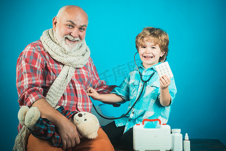 小医生一边向老祖父展示平板电脑一边笑着。