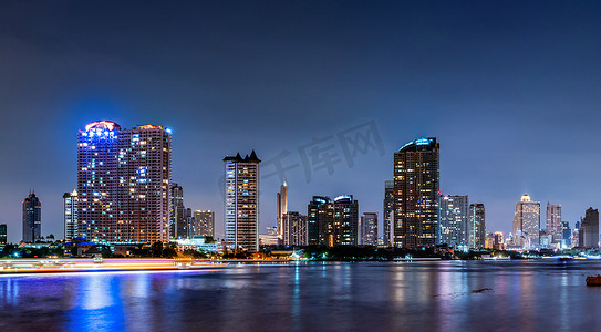 河边背景摄影照片_夜间河边现代建筑的城市景观。