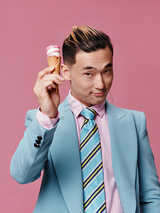 穿着冰淇淋套装、手持欢乐生活方式粉色背景的优雅男士