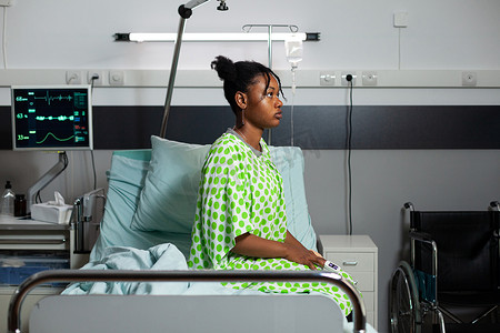 坐在医院病床上的年轻非洲裔美国人