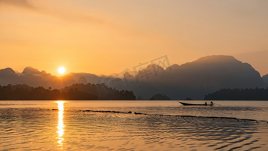 早上在泰国南部的一座水坝​​中航行的船的轮廓图像。
