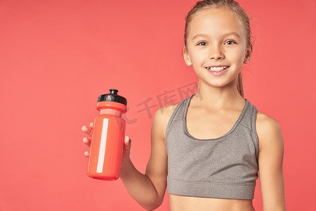 可爱瓶瓶摄影照片_拿着瓶水的可爱的运动女孩