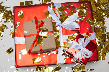 新年圣诞礼物有丝带、金色五彩纸屑、顶视图。 