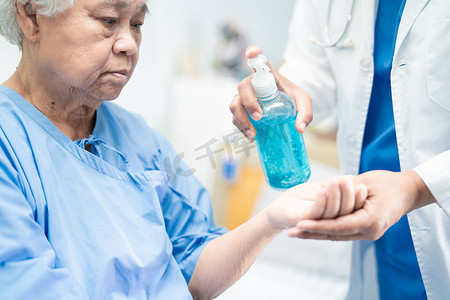 消毒凝胶摄影照片_COVID-19 冠状病毒大流行后，医生将蓝色酒精消毒凝胶推向新常态。