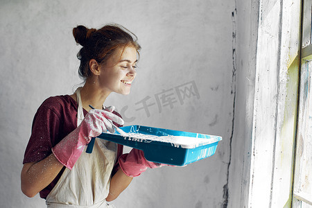室内装修中摄影照片_家庭室内装修中手拿刷子油漆的女人