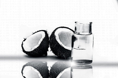 生有机切干椰子连同水一起放在一个透明玻璃瓶中，用白色隔开，并带有反射。