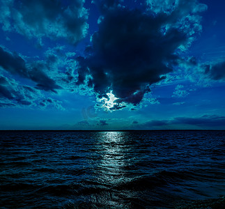 这张深蓝色月光下的海洋在夜间平静的波浪的照片插图将成为任何沿海地区或度假的绝佳旅行背景。