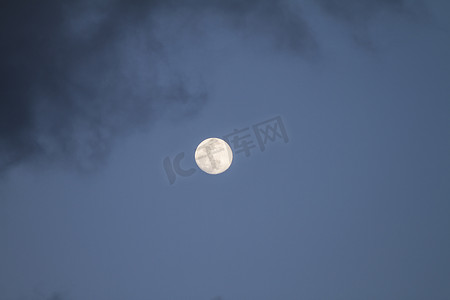 山水灰色摄影照片_满月在深蓝色的天空中升起，有些灰色的云