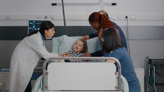 住院的病童在接受疾病检查时，医疗队抱着她，疼痛发作