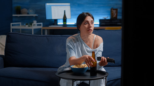 使用遥控器切换电视频道,搜索搞笑电影的女人