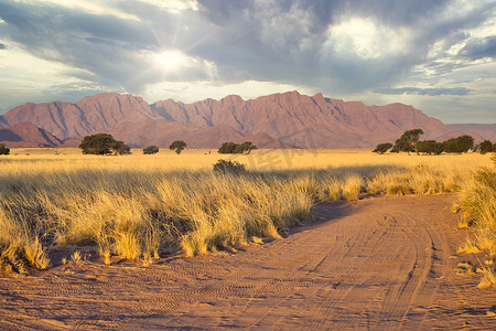 越野摄影照片_越野 4x4 吉普车土路在 Sossusvlei 纳米比亚沙漠景观。