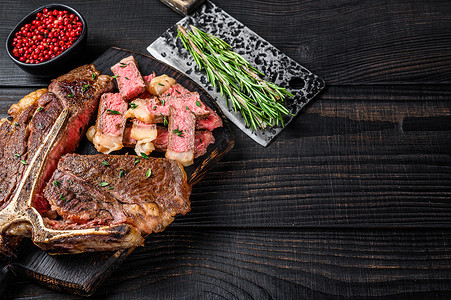 丁肉摄影照片_牛排馆菜单上的切片和烤丁骨或上等腰肉牛排。
