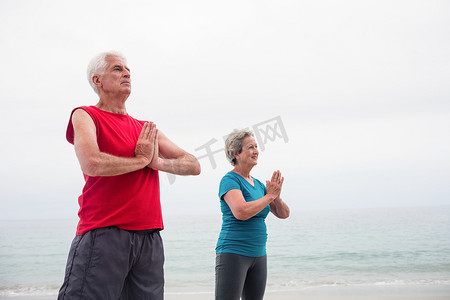 年长夫妇在沙滩上的莲花位置