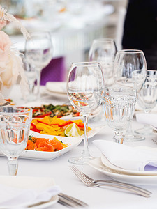 餐桌上有餐具和花瓶中的鲜花供婚宴使用。