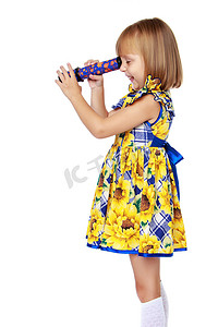 一个小女孩看着望远镜或万花筒。