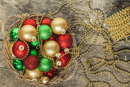 圣诞球红色、金色、绿色、珠子放在木篮里