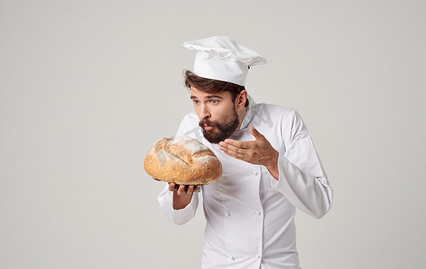 厨师手里拿着一条面包，背景浅色，职业服装裁剪视图