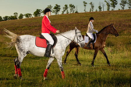 两个年轻女子在公园里骑马。