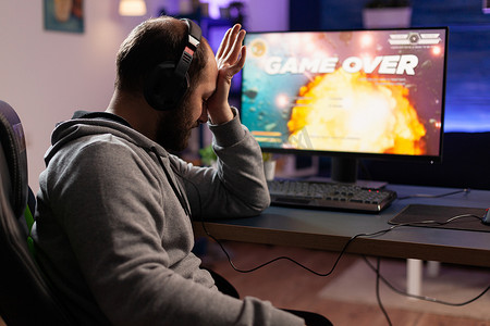悲伤的玩家在电脑上玩电子游戏失败