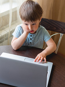 好奇的蹒跚学步的男孩探索笔记本电脑并按下 c 上的按钮