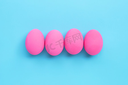 复活节彩蛋，蓝色背景上的粉红色彩蛋。