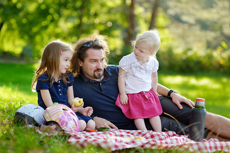 女儿们摄影照片_父亲和他的女儿们在公园野餐