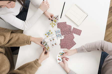 卡扑克牌通摄影照片_顶视图朋友玩纸牌游戏。