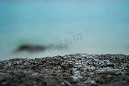 黑色石头摄影照片_选择性聚焦 od 黑色石头纹理，用于放置产品以与海滩一起展示。