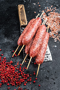 生卢拉或科夫塔烤肉串放在屠夫切肉刀上，加盐和胡椒。