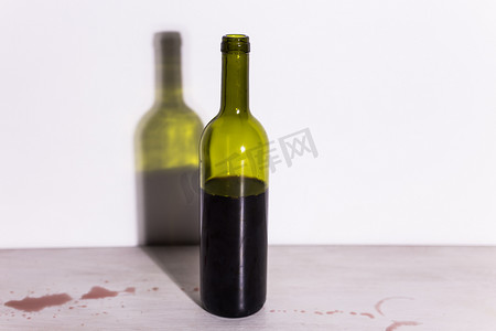 瓶子里装着酒，桌子上有一滩红色的酒。
