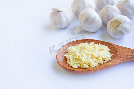 在木匙子的新鲜的切好的大蒜有在白色的大蒜头的。