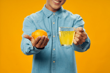 一个手里拿着柠檬的男人，杯子里有饮料药