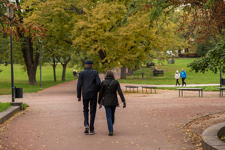 秋季保健摄影照片_2020 年秋季，捷克共和国，布拉格 6 日，由于 COVID-19 爆发，捷克共和国在隔离期间，男女正在莱特纳公园散步和交谈