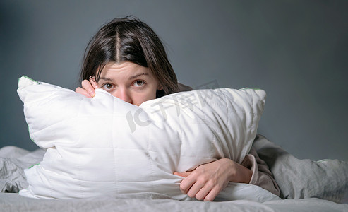 梦魇摄影照片_女人盖着毯子，担心失眠和压力。