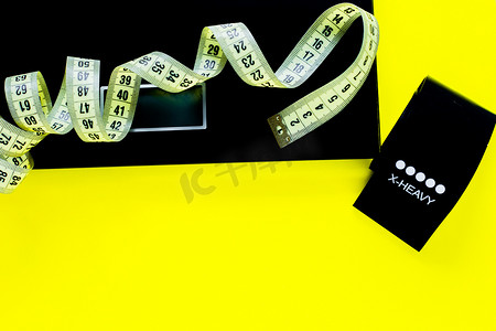 体重秤、黑色健身带和黄色测量器