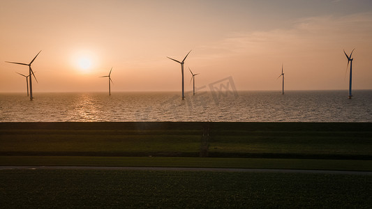 海上风力发电摄影照片_用于发电的风车荷兰弗莱福兰，海上风力涡轮机农场，生产绿色能源的风车农场。