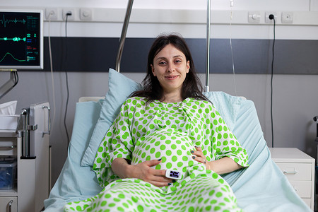 坐在医院病床上的孕妇肖像