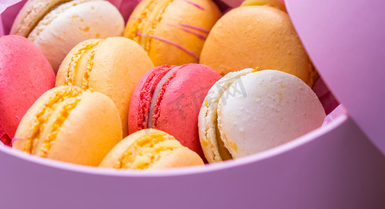 色彩缤纷的法式饼干马卡龙装在粉色礼品盒中。