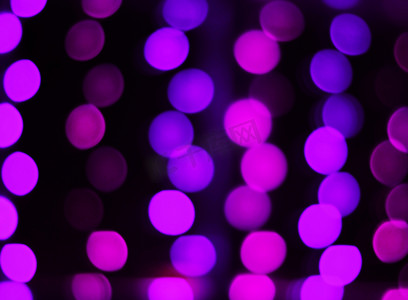 紫色灯光摄影照片_黑色背景上紫色灯光的模糊图像