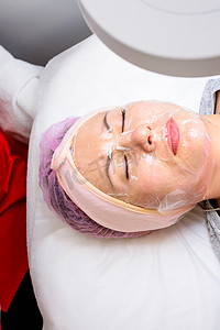 面膜美容摄影照片_女人脸上的透明面膜膜，拜访美容师，面部护理。