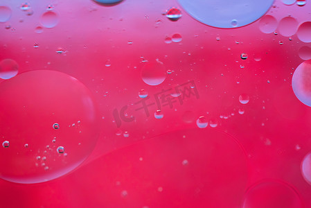 肥皂泡泡摄影照片_用油、水和肥皂制成的红色抽象背景图片