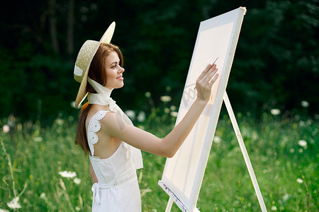 大自然中穿白裙的女人描绘了一幅风景爱好的图画