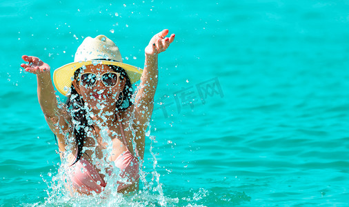 身穿粉色泳衣的快乐亚洲年轻女性放松身心，享受假期